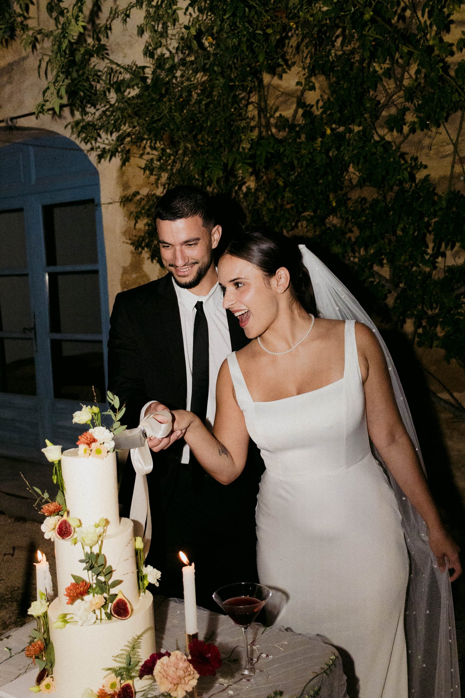 Couple devant un gâteau de mariage décoré de fleurs